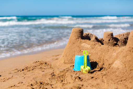 Children’s toys and Builded sand castle  structure on the beach