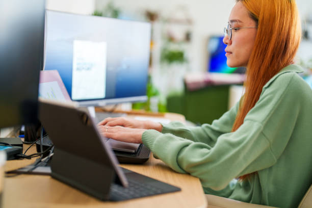 istock Young woman working on multiple screens at home office 1485679025