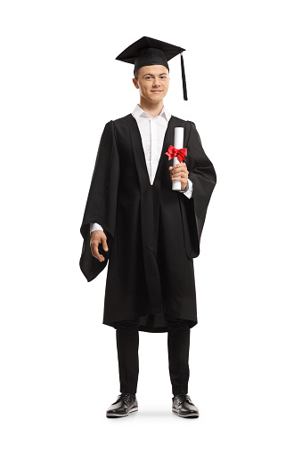 Full length portrait of a smiling male student wearing a graduation gown and holding a diploma isolated on white background