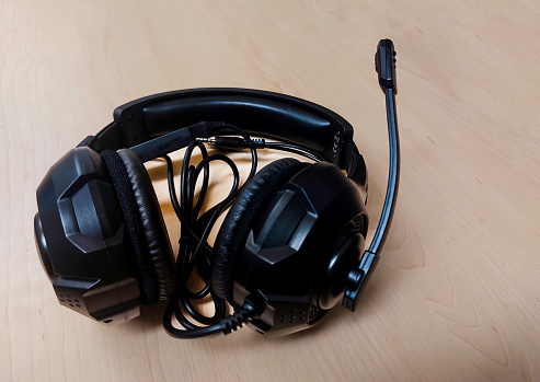 Black headphones on wooden background.