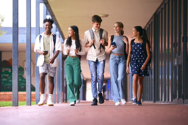 Group Of Multi-Cultural High School Or Secondary School Pupils Outdoors Walking To Class stock photo