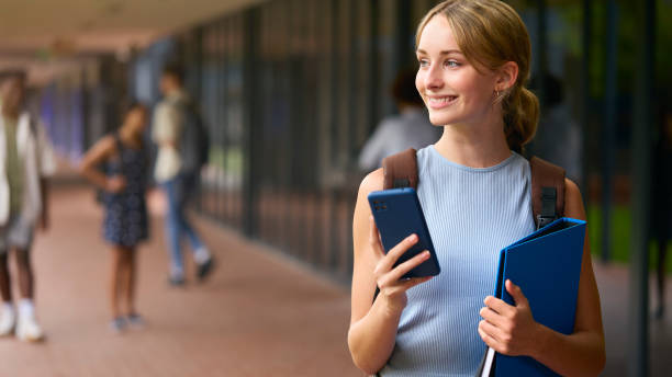 istock Female Secondary Or High School Student Outdoors At School Going To Class Looking At Mobile Phone 1485686535