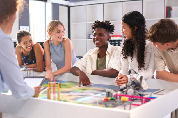 istock Female High School Teacher With Digital Tablet Helping Students In STEM Technology Lesson 1485688449