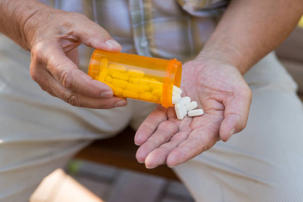 istock Elderly hand holds pills. 1485690199