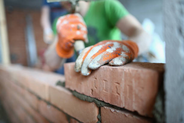 istock Bricklayer lays bricks on cement building exterior or interior walls 1485690855
