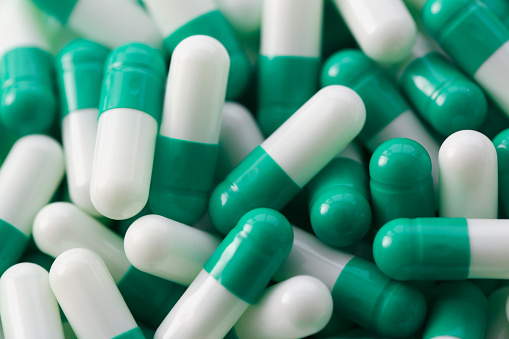 Lots of medical white green pills and vitamins. Development of the concept of the pharmaceutical industry