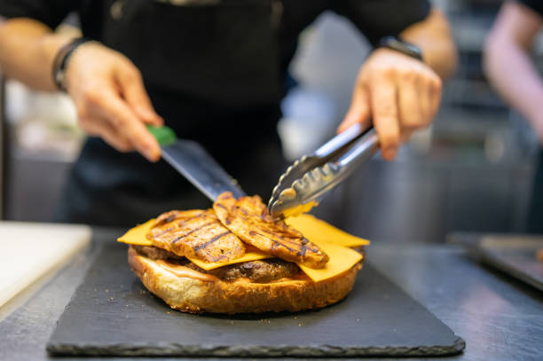 istock chef hand cooking big large cheese burger on restaurant kitchen. step by step 1485692490