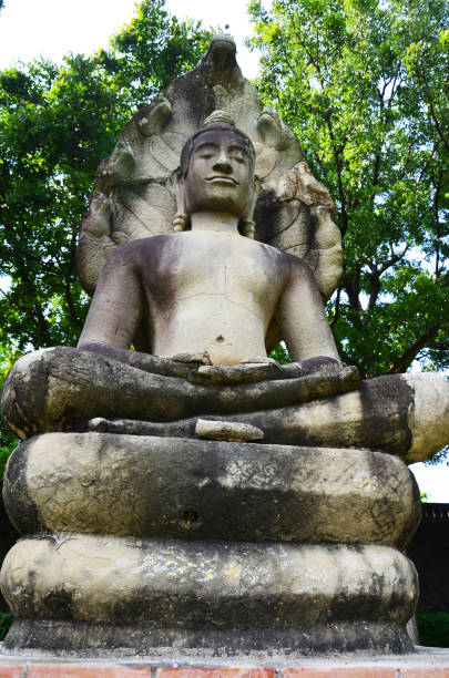 Ancient buddha attitude of meditation protected cover head by mythical serpent or antique Naga Prok for thai people visit praying of King Narai Ratchaniwet Palace at Lopburi city in Lop Buri, Thailand la antigua actitud de buda de meditación protegida por la cabeza cubierta por la serpiente mítica o el antiguo naga prok para los tailandeses visita la oración del palacio del rey narai ratchaniwet en la ciudad de lopburi en lop buri, tailandia