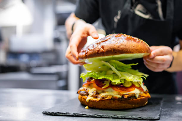istock chef hand cooking big large cheese burger on restaurant kitchen. step by step 1485693180