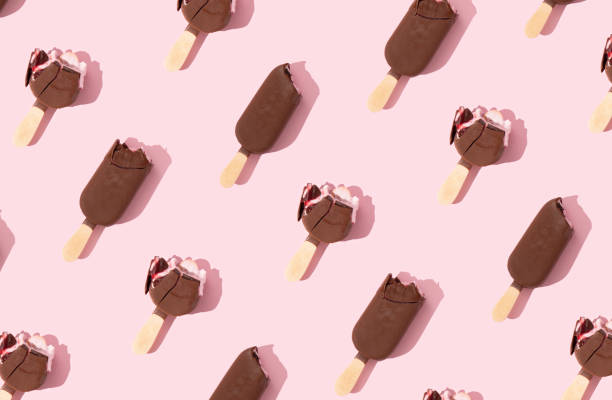 istock Chocolate ice cream pattern on stick on pastel pink background. Crispy, tasty and refreshing sweetie dessert. Minimal Summer frozen food concept. Top view. Flat lay 1485693186