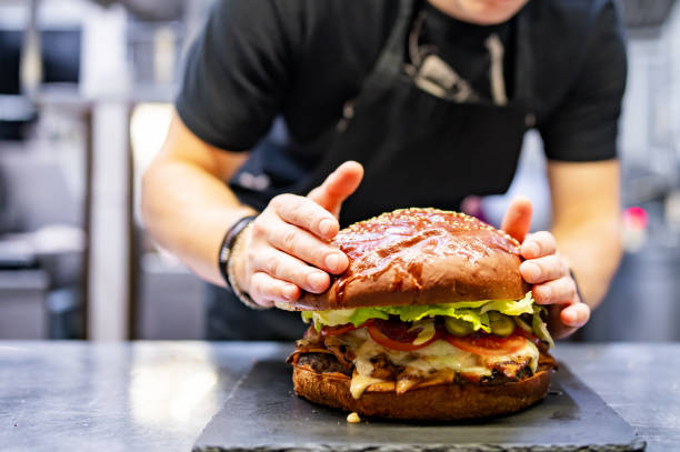 istock chef hand cooking big large cheese burger on restaurant kitchen. step by step 1485693198