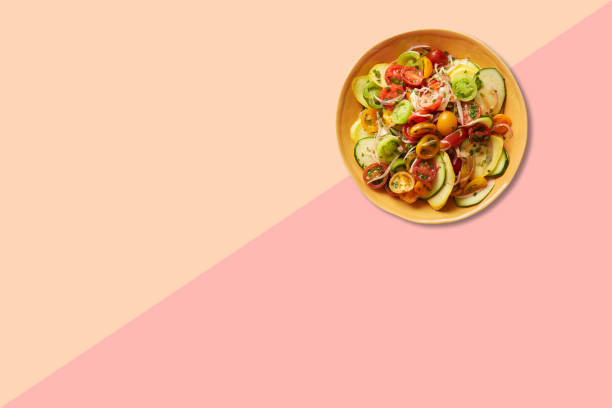 istock Close up view vegetable salad on brown plate isolated on pink background. 1485694189