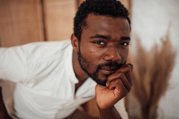 Portrait of candid authentic handsome dark skinned man posing at home in natural lighting