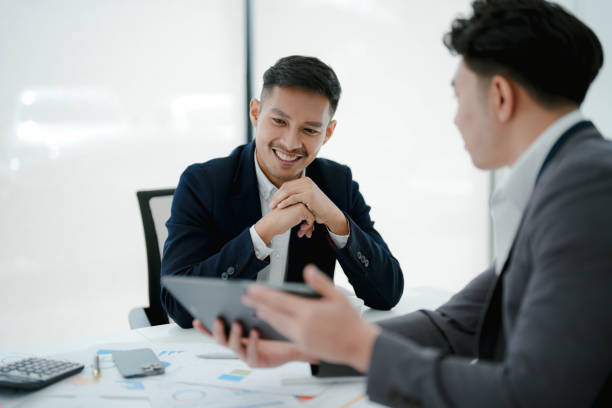 istock Two business men meeting to talking or discuss marketing work in workplace using paperwork, calculator, computer to work. 1485698235