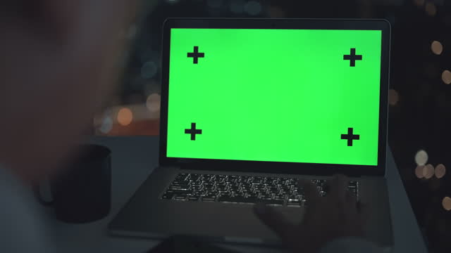 Dolly shot of businessman using chroma key computer laptop for working in the office at night,Close-up