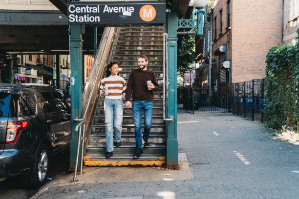 A millennial couple is exiting from the elevated train station in Bushwick, Brooklyn