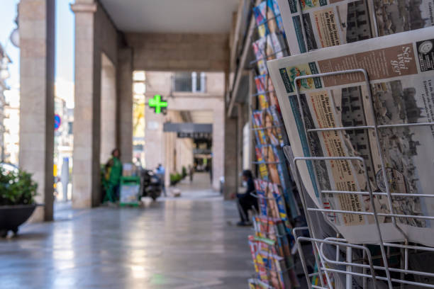 Ragusa, Sicily, Italy: A senior man sitting at an outdoor cafe reading a newspaper in Palazzolo Acreide, Sicily, a UNESCO World Heritage Site. Palazzolo is in Siracusa Province.