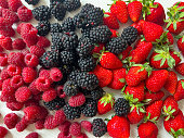 Berries strawberries, blackberries, raspberries are piled on the table, background, top view