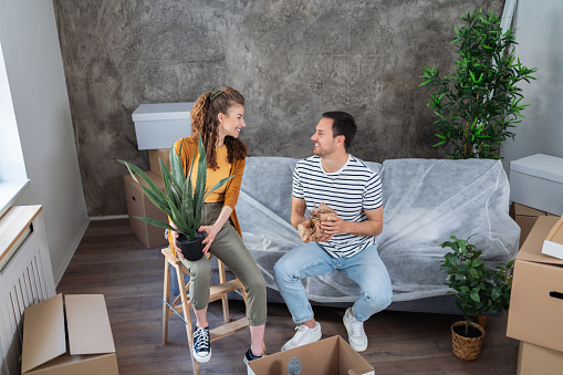 Young Caucasian couple unpacking, after they moved in, into their new apartment