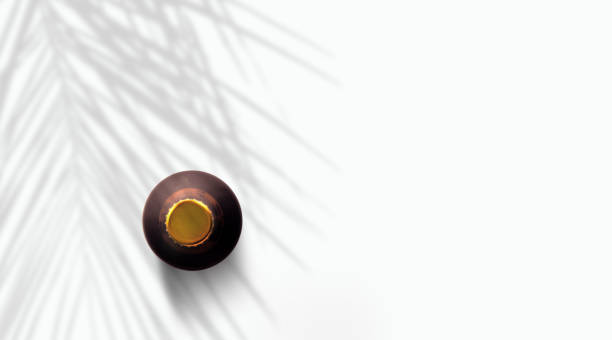 istock Top up view dark brown beer bottle under palm tree isolated on white. 1485712553