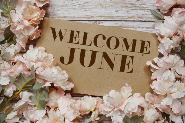 istock Welcome June typography text with flowers frame on wooden background 1485719490