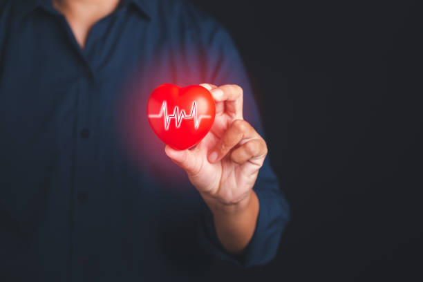 istock A young man in a blue shirt holding a red heart shape and light effect on a virtual screen interface while standing on a black background. 1485720719