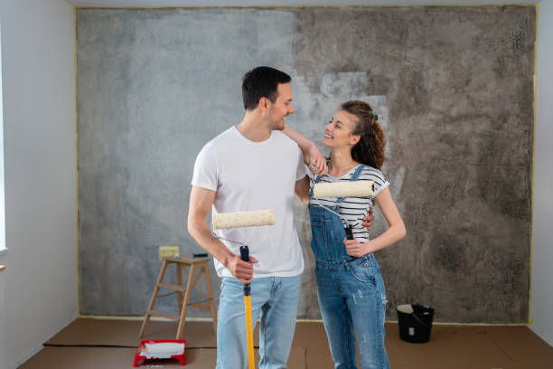 retrato de una pareja caucásica, renovando su nuevo apartamento - home improvement couple painting real estate fotografías e imágenes de stock