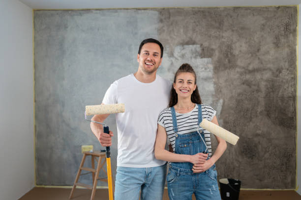retrato de una pareja caucásica, renovando su nuevo apartamento - home improvement couple painting real estate fotografías e imágenes de stock