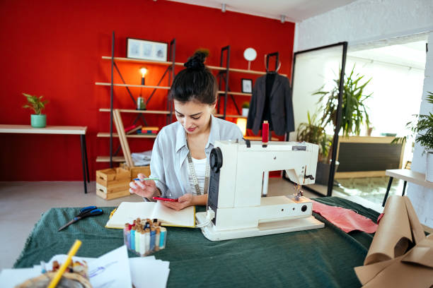 istock Seamstress is using a mobile phone 1485731627