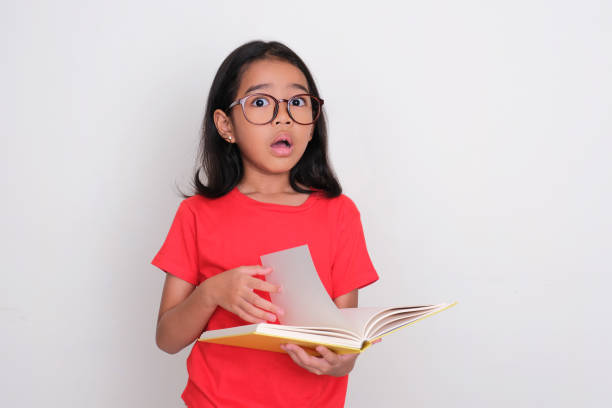 istock Asian kid holding a book and showing shocked expression 1485732128