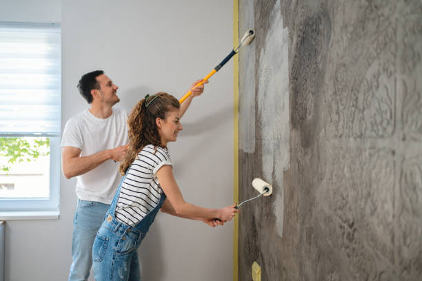 pareja caucásica pintando la pared en el nuevo apartamento - home improvement couple painting real estate fotografías e imágenes de stock