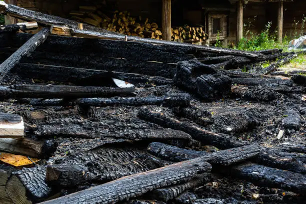 Photo of Destroyed by fire wooden house completely burned to the ground .ruins of a burnt wooden house after a fire