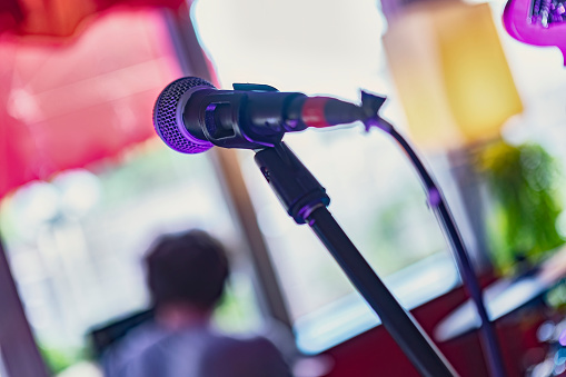 A detailed photo of a black live performance microphone on stage. Perfect for music events, concerts, and entertainment themes.