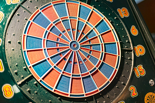 Detailed close-up shot of a dartboard with multiple darts hitting the center bullseye.