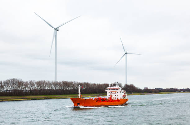 istock A tanker ship passing through a canal in the Netherlands with wind generators on the shore. 1485742948