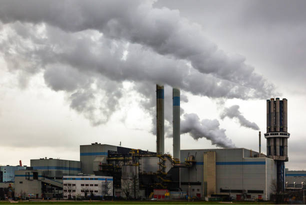 istock An industrial plant with chimneys from which thick smoke comes out into a cloudy sky. Environmental pollution by industry. 1485742949
