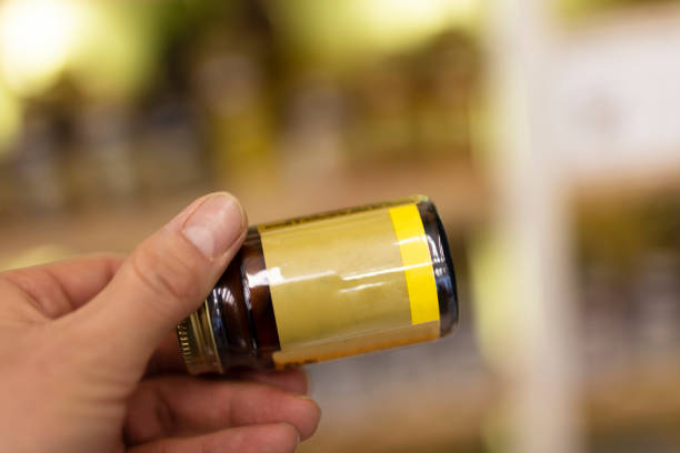 istock Customer in pharmacy holding Vitamin Pill bottle. 1485746975