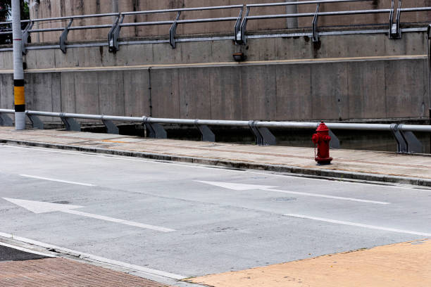 Lonely red fire hydrant stands out amidst the gray and industrial surroundings of Medellin, Colombia.