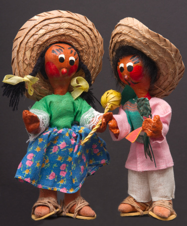 A male and female mariachi doll isolated on a gray background.