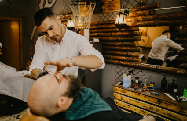 istock Young barber styling client´s beard at the barber shop 1485755423