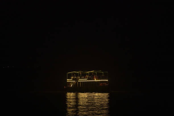Varanasi, Uttar Pradesh, India - November 2022: People riding on boat in river ganges during night time.