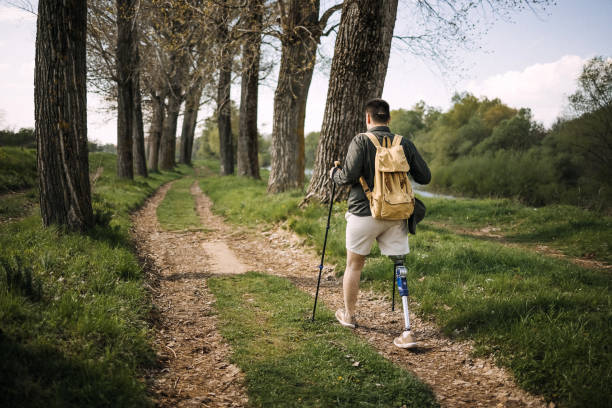 Hiking in the forest Disabled young man with artificial leg hiking disabled person hiking outdoors stock pictures, royalty-free photos & images
