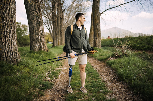Disabled young man with artificial leg hiking