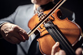 Violinist player hands playing violin performing in an orchestra