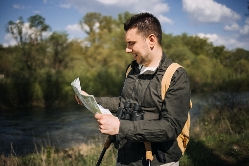 Hiker standing in nature and looking at map