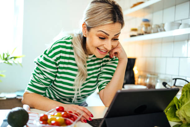 istock Woman cooking at home, using digital tablet, 1485761747
