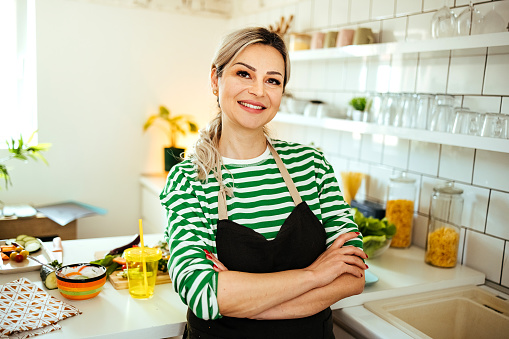 Cheerful  woman standing in the kitchen