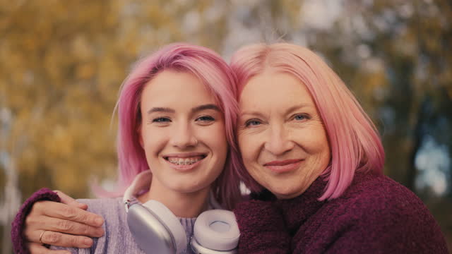 Portrait of stylish pink-haired mother and daughter, bonding relationship, love