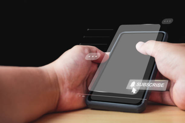 istock Man holds an unidentified smartphone. Click on subscribe button. Social media concept with copy space. 1485766098
