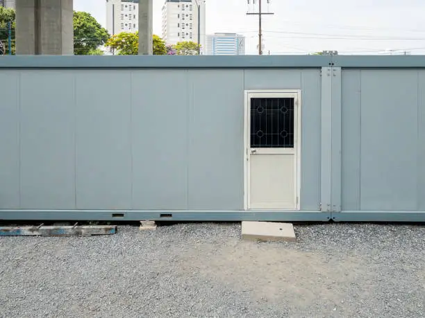 The container box  for use to the temporary office room in the construction site, near the skywalk project in the city,front view with the copy space.